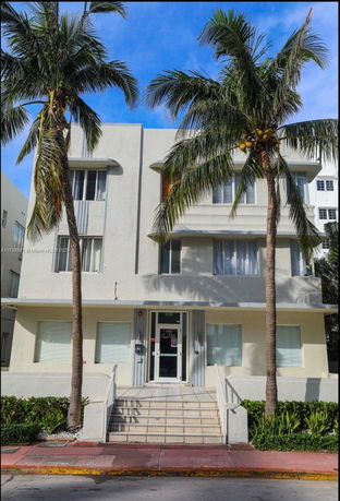 Front view of a multi-story building with palm trees.