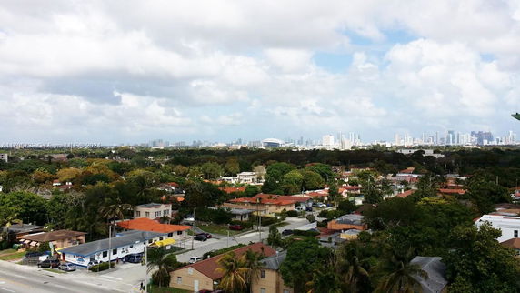 Panoramic view of a cityscape with urban buildings and greenery.