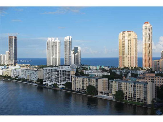 Aerial view of a coastal cityscape with high-rise buildings adjacent to the ocean.