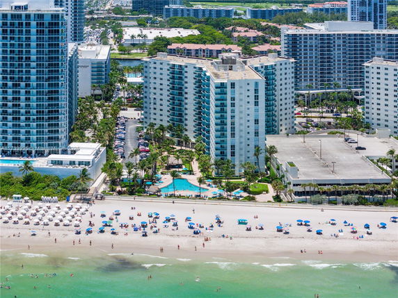 Aerial view of beachfront buildings and sandy beach.