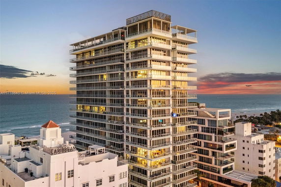 High-rise building with ocean in the background during sunset.