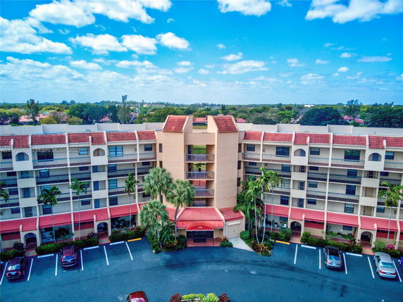 Front view of a multi-story residential building with red-tiled roofing and balconies.