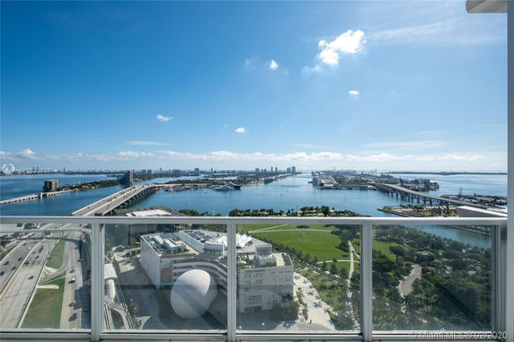 Wide-angle view from a building showing a bridge, water body, and urban landscape.