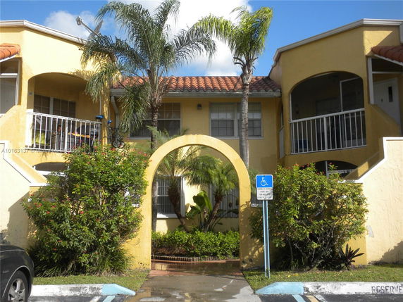 Front view of a two-story building with arches and balconies.