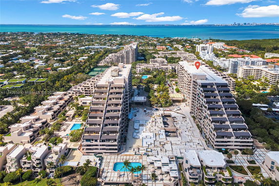 Aerial view of a coastal city with multiple residential buildings and a visible coastline in the background.
