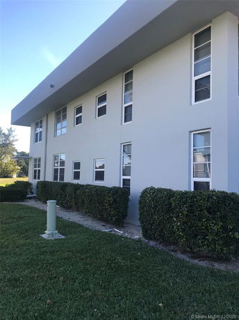 Side view of a two-story building with multiple windows.