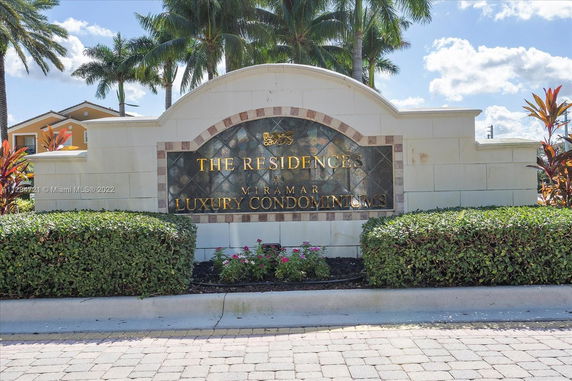 Entrance sign for luxury condominiums with decorative landscaping.