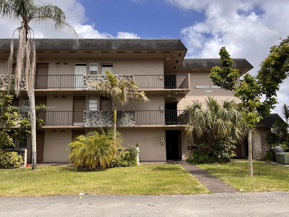 Front view of a three-story apartment building with balconies.