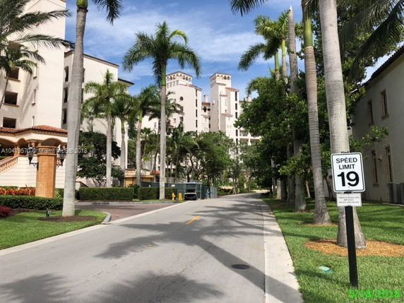 View of residential buildings with palm trees lining the street.