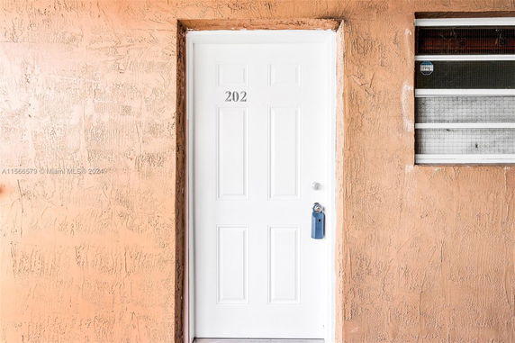 Entrance view of a building door with a number 202 on it.