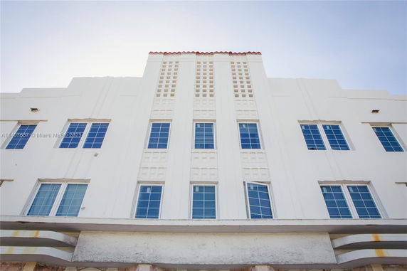 Front view of a multi-story building with grid-like windows and decorative facade.