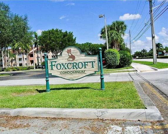 Front view of a condominium complex with signage for Foxcroft Condominium.