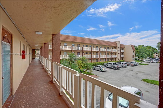 View of a multi-story residential building with parking area.