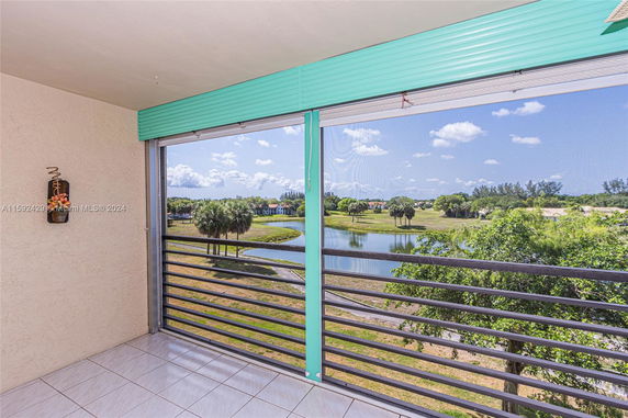 View from a balcony overlooking a pond and greenery.
