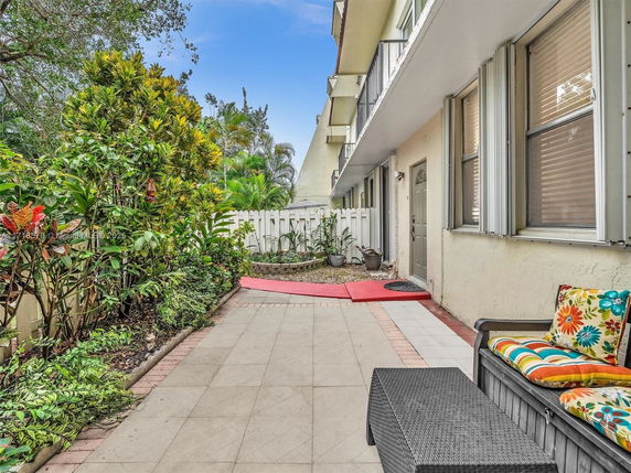 View of the exterior area next to a building with plants and seating.