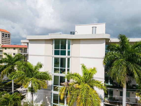Front view of a multi-story building with large windows and a flat roof.