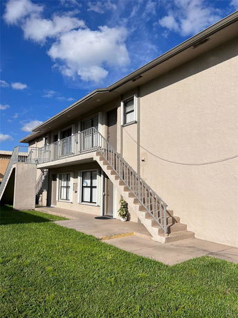 Front view of a two-story building with exterior stairs.