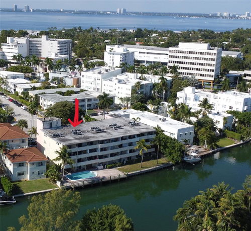 Aerial view of a multi-story building with a rooftop containing air conditioning units.