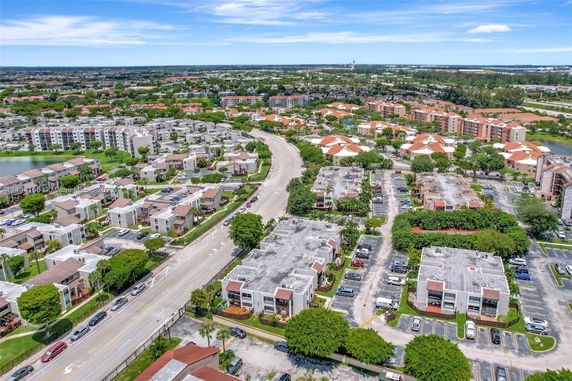 Aerial view of a residential area with multiple apartment buildings, parking lots, and green spaces.