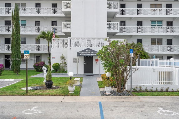 Front view of a multi-story condominium building with balconies.