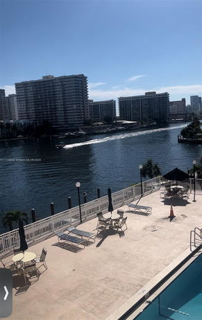 View of waterfront area with high-rise buildings and a swimming pool.