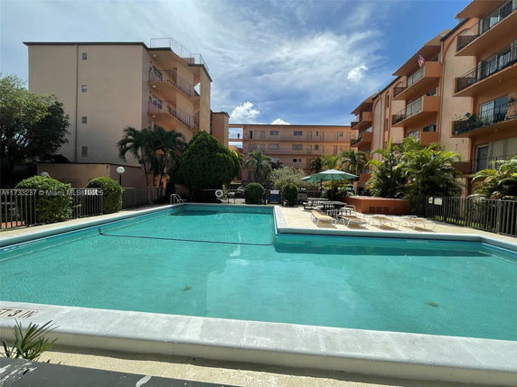 Outdoor view of a swimming pool with surrounding apartment buildings.
