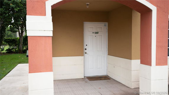 Front view of a building entrance with a white door marked 'Unit 3307'.