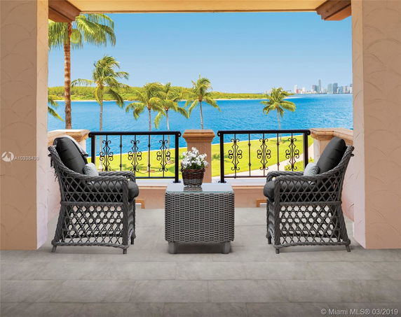 Covered outdoor seating area with a view of the water and distant city skyline.