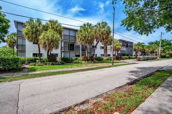 Front view of a multi-story apartment building with screened balconies.
