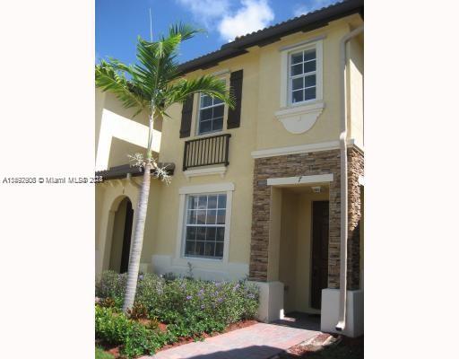 Front view of a two-story house with decorative stone accents and a small front entrance.