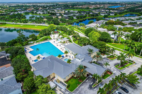 Aerial view of a residential area with a large swimming pool and adjacent buildings.