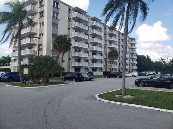Front view of a multi-story apartment building with balconies.