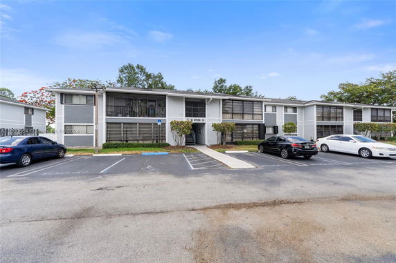 Parking area in front of a two-story residential building.