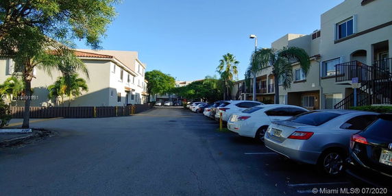 Outdoor parking area next to multi-story residential buildings.