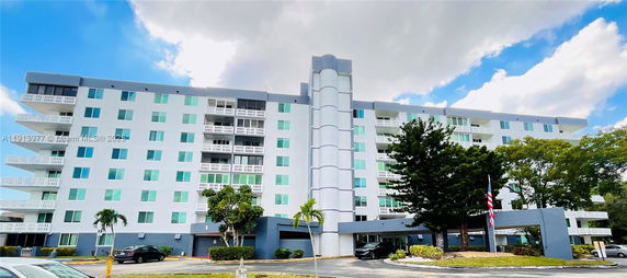 Front view of a multi-story residential building with balconies and a modern facade.