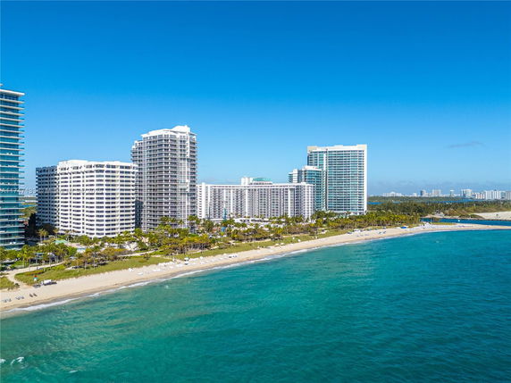 Aerial view of beachfront high-rise buildings with ocean and beach in the foreground.