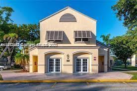 Front view of a two-story gym building with arched windows and doors.
