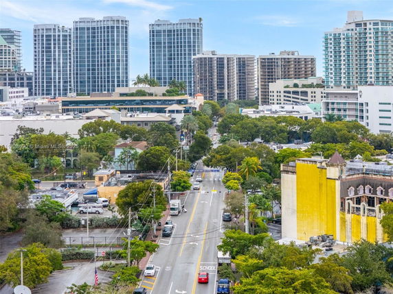 Urban view with multiple high-rise buildings and a tree-lined street.