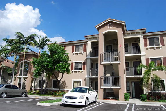 Front view of a three-story apartment building with balconies.