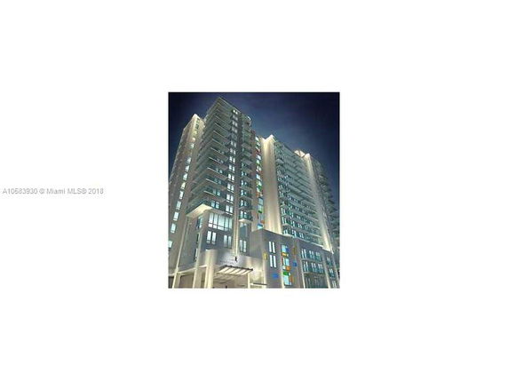 Front view of a multistory modern building at night with illuminated facade.