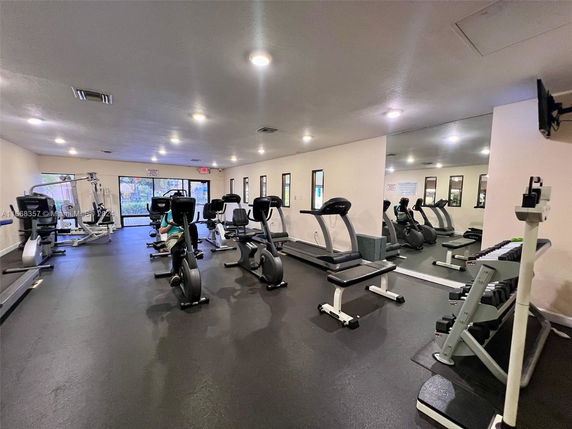 Indoor gym with exercise equipment including treadmills and stationary bikes.