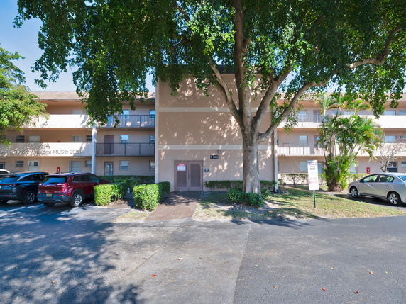 Front view of a three-story apartment building with balconies.