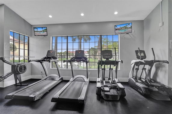 Indoor gym area with exercise equipment and large windows.