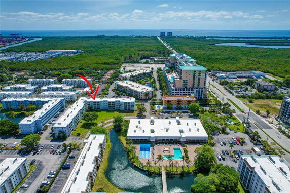 Panoramic aerial view of a residential complex with multiple buildings and a swimming pool.