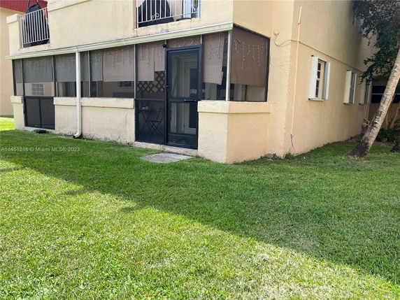 Front view of a building with a screened patio area on the ground floor.