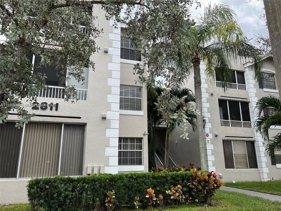 Front view of a multi-story building with balconies and white trim.