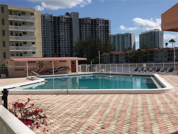 View of a swimming pool area with high-rise buildings in the background.