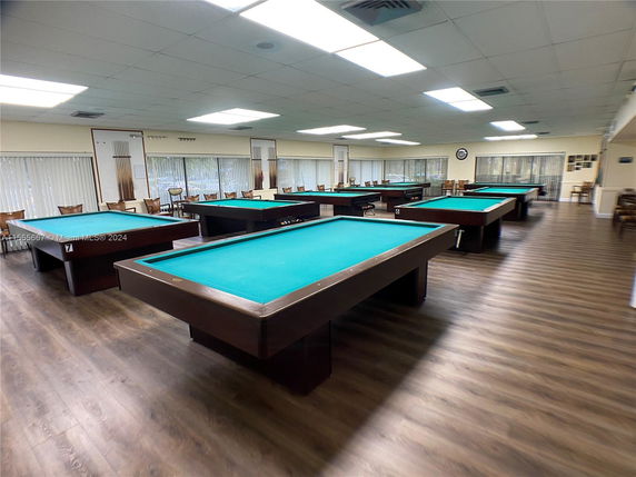 Recreation area with multiple billiard tables and chairs