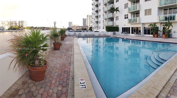 Panoramic view of a high-rise building with adjacent swimming pool.