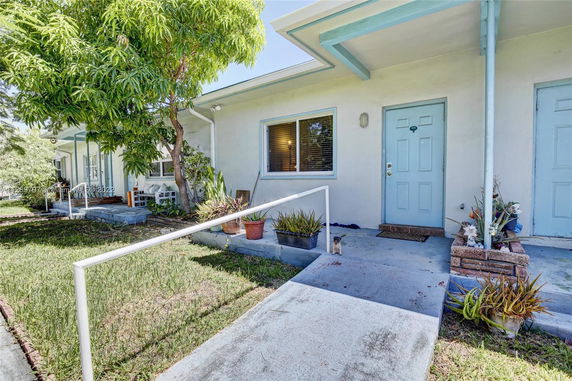 Front view of a single-story house with a light blue door and small porch.